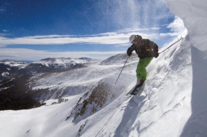 Guy about to drop a cornice on skis